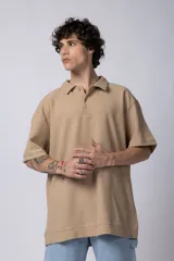 Chomba de manga corta con cuello polo, confeccionada en tejido de punto acanalado de textura pesada. Presenta un calce relajado y cuenta con una pequeña etiqueta distintiva en el ruedo.