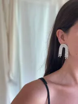 Aros colgantes plateados con forma de arco y strass.