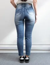 Jean skinny de denim azul con efecto lavado. Pretina con pasadores, botón y cierre. Delantera y trasera con bolsillos.