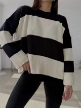 Sweater de punto con diseño de rayas horizontales anchas en color negro y blanco, cuello redondo, manga larga y corte holgado.