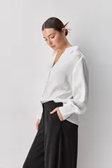 Pantalón wide leg de tiro medio y calce amplio, color marrón, con pinzas delanteras, cierre frontal y bolsillos laterales funcionales.