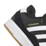 Championes Adidas modelo Tyshawn II, color negro con detalles en blanco y suela de goma color caramelo. Presentan el nombre Tyshawn en dorado en el lateral y las icónicas tres bandas de la marca en blanco.