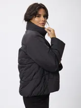 Campera puffer de nylon color negro, con cuello alto, cierre frontal con cremallera y botones a presión. Presenta bolsillos frontales con solapa y diseño acolchado.