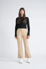 Pantalón de vestir color beige con corte de pierna tipo trompeta y cintura con pasa cintos.
