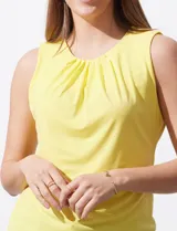 Musculosa negra de poliéster y elastano, con cuello redondo con frunces delanteros y abertura con botón en la espalda.