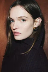 Par de aros pequeños de metal con diseño moderno. Cada pendiente consiste en una esfera dorada montada sobre una base curva plateada. Cierre a presión.