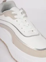 Zapatilla de plataforma con diseño de recortes en tonos blanco, beige y detalles metalizados plateados. Cuenta con suela texturizada y cierre mediante cordones.
