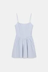 Vestido mini con estampado de cuadros vichy en color celeste y blanco, con escote redondo, tirantes finos ajustables, varillas interiores y falda con volumen.