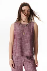 Top sin mangas de corte recto y holgado, confeccionado en tejido de lino con textura jaspeada en tono azul. Presenta cuello redondo y un diseño minimalista ideal para climas cálidos.