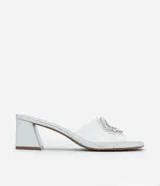 Sandalia mule con puntera cuadrada, capellada de vinilo transparente con aplique de pedrería plateada y tacón bloque plateado.