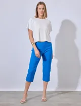 Pantalón capri azul eléctrico de gabardina elastizada, con bolsillos simulados en la parte delantera y bolsillos aplicados en la parte trasera. Tiene pretina ancha, corte recto y detalle calado en el ruedo.