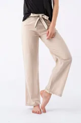 Pantalón de vestir color beige, de corte recto, con lazo ajustable en la cintura con sesgos negros.