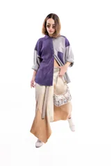 Falda midi cruzada de lana con diseño asimétrico y efecto degradé en tonos tierra. Presenta una estructura envolvente con ajuste mediante broches metálicos a presión.