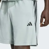 Short deportivo Adidas color verde claro, con las icónicas tres tiras laterales en negro y logo de la marca estampado en la pierna. Cuenta con cintura elástica y bolsillos laterales.