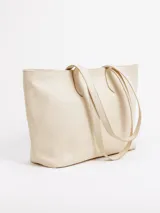 Cartera shopper grande de cuero color beige con diseño trenzado. Cuenta con asas largas de hombro, cierre superior y forro interior con bolsillos.