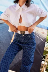 Jean de tiro bajo y corte oversize, confeccionado en denim azul con monograma grabado a láser en toda la prenda. Presenta doble botón metálico en la cintura y diseño de cinco bolsillos.