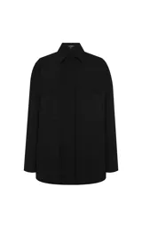 Camisa negra de tejido de punto con corte recto y ligeramente holgado. Presenta cuello estructurado, cierre frontal con botones, mangas largas con puños, bolsillo de parche delantero y bajo redondeado.
