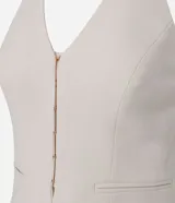 Blusa sastrera color marfil de corte halter con escote en V, cierre frontal con ganchos y bolsillos ribeteados simulados.