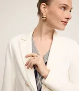 Blazer femenino de sastrería confeccionado en punto roma, con cuello solapa, cierre frontal con botones decorativos y diseño estructurado.