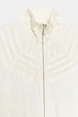 Bomber de viscosa color blanco crudo, de corte holgado, cuello subido y cierre frontal con cremallera. Presenta mangas abullonadas con puños ajustados y detalle de tejido satinado en la parte superior delantera.