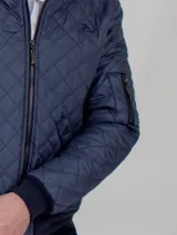 Campera bomber aviador azul con cuello alto, cierre frontal y bolsillos laterales. Diseño acolchado con patrón de rombos.