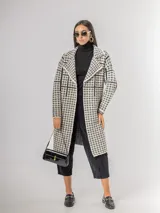 Sacón tipo tapado de corte recto y largo midi, con diseño de estampa pied de poule y solapas clásicas. Confeccionado en tejido abrigado y liviano, ideal para media estación.