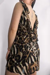 Vestido corto de gasa con estampado animal print en tonos marrones y beige. Tiene escote en V pronunciado en la espalda con volados en los bordes.