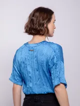 Blusa naranja de manga corta con escote en V y textura plisada.