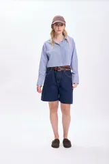 Camisa cropped de mangas largas con puños abotonados, de corte holgado y con estampado de rayas verticales azules y blancas.