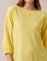 Blusa amarilla texturada con escote redondo y mangas 3/4 con puño elastizado. Aplique de broderie en escote y mangas. Marca Ruby Rd.