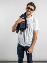 Remera blanca de corte regular con estampado gráfico en la espalda que incluye elementos icónicos de la cultura uruguaya como el sol, un tambor, una parrilla y frases alusivas. Cuenta con cuello redondo y mangas cortas.