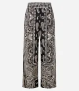 Pantalón largo de corte ancho con estampado paisley en tonos blanco y negro. Presenta cintura alta con trabillas, cierre frontal tradicional y confección en tejido viscolino, una mezcla de lino y viscosa.