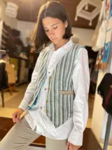 Chaleco reversible de corte clásico, con diseño de rayas verticales en tonos verde, gris y blanco en un lado, y ribetes en contraste.