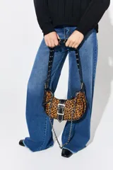 Cartera bandolera de cuero vacuno con estampado animal print de leopardo. Tiene correa de cuero con apliques metálicos y cadena plateada.