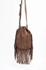 Cartera tipo bucket bag color camel, confeccionada en material sintético con acabado gamuzado. Presenta un diseño decorado con flecos largos en todo el contorno, cierre mediante cordón ajustable y correa larga regulable.