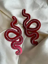 Aros colgantes con forma de serpiente blanca delineada con strass plateado.