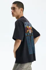Remera oversized de algodón pesado color negro, con cuello redondo acanalado, hombros caídos y estampa frontal de Guns N' Roses con diseño de calavera y rosas.