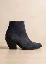 Bota corta de cuero vacuno en color azul oscuro, con diseño de caña media, punta almendrada y taco cuadrado de 7 cm. Presenta costuras decorativas laterales y suela de caucho antideslizante.