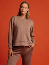 Buzo blanco de tejido elastizado, con pespunte central en la parte delantera y tajos laterales.