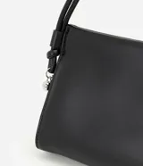 Bolso pequeño tipo bowling de estructura flexible y acabado liso. Cuenta con asa de hombro fija ajustable mediante nudos laterales y cierre magnético.