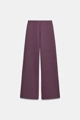 Pantalón de corte ancho y tiro alto, confeccionado en tejido de punto interlock elástico y flexible. Presenta cintura elástica y diseño minimalista de líneas rectas.