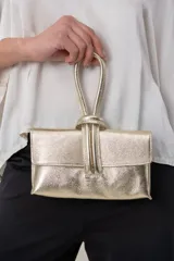 Cartera italiana de cuero laminado dorado, con solapa frontal y manija superior tipo lazo.
