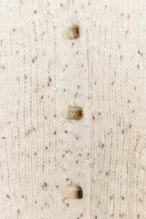 Chaqueta de punto con diseño jaspeado, escote en pico y manga larga. Presenta cierre frontal con botones, bolsillos delanteros de plastrón y acabados en rib.