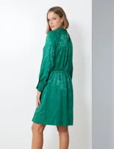 Vestido corto color borgoña con estampado geométrico, de gasa laminada con cuello alto entrelazado, manga larga raglán, cintura elastizada y espalda con abertura ojal y botones.