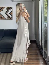 Vestido largo color marrón con breteles finos y volados asimétricos en el ruedo.