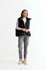 Chaleco puffer de corte holgado y diseño acolchado, con cuello alto y cierre frontal oculto. Presenta cordón ajustable en el ruedo inferior y bolsillos laterales.