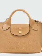Cartera tipo tote en tamaño extra pequeño, confeccionada en cuero de color verde oliva. Presenta una estructura rígida con asas cortas redondeadas y un cierre de solapa con broche metálico dorado grabado con el logo de la marca.