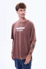 Remera de algodón con efecto lavado, color marrón, de corte oversize, cuello redondo y manga corta. Presenta una estampa frontal con el texto 'CONFIRM the future' en color blanco.