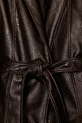 Chaqueta de Zara Woman Collection confeccionada en tejido efecto piel con textura granulada. Presenta cuello solapa, manga larga y cierre frontal con cinturón ajustable mediante lazada. Incluye forro interior.