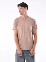 Remera de manga corta color beige, con cuello tipo henley con dos botones frontales y textura de tejido fino.